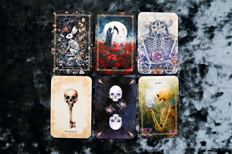 Six tarot cards with skeleton and skull illustrations on a dark velvet background
