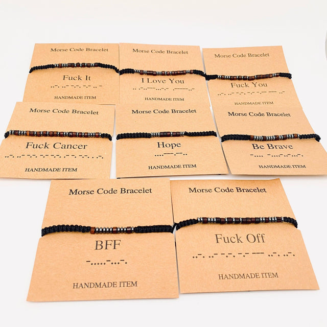 Assorted handmade morse code bracelets with inspirational and bold messages on kraft cards
