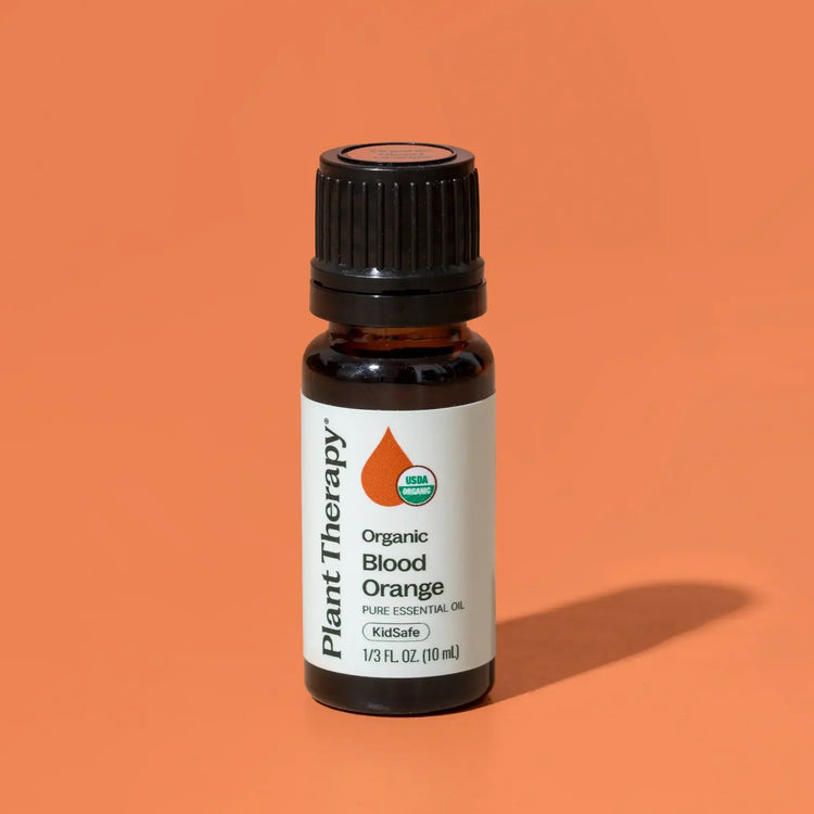 Plant Therapy organic blood orange essential oil bottle on an orange background