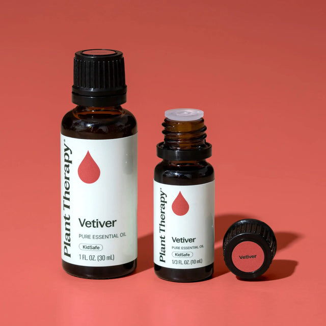 Plant Therapy Vetiver pure essential oil bottles on coral background, holistic wellness product