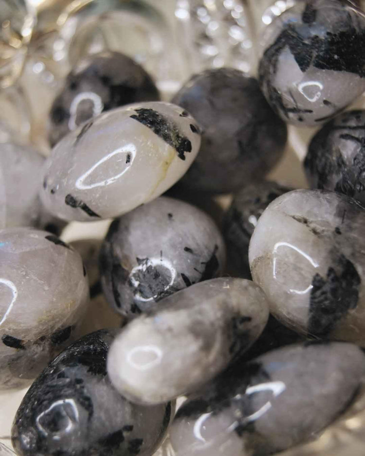 Tumbled black tourmaline quartz crystals with natural inclusions, close-up view
