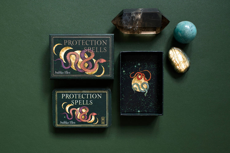 Protection Spells card deck with illustrated snake design, crystal points, and polished stones on green background