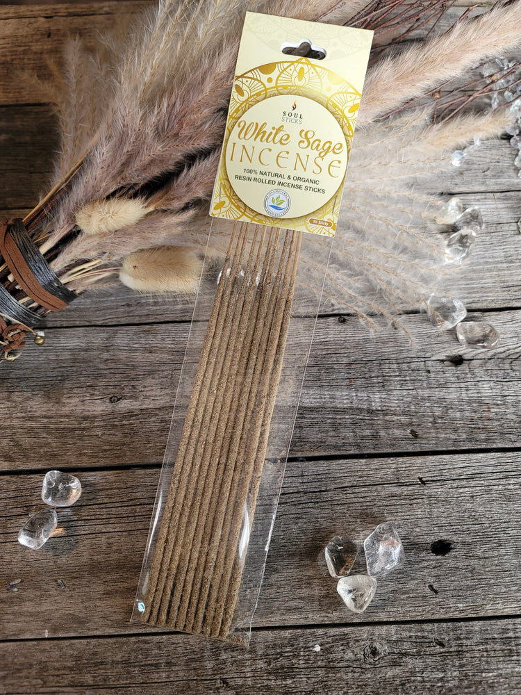White sage incense sticks in packaging on rustic wood with crystals and dried pampas grass