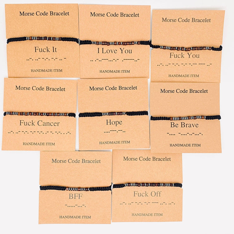 Assorted handmade morse code bracelets with different messages on kraft cards