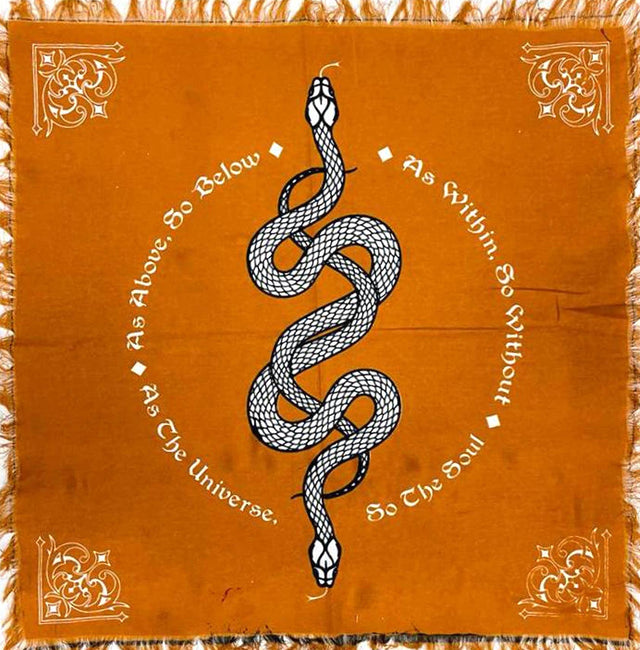 Orange altar cloth with black snake, ornate corners, and metaphysical affirmation text