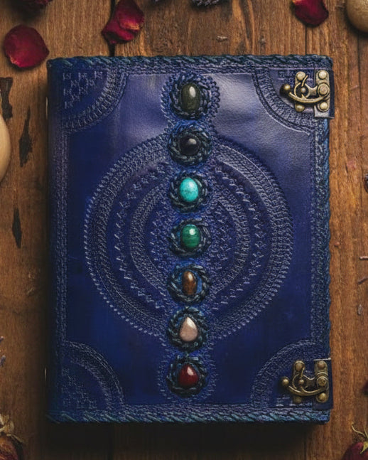 Blue leather journal with chakra stones and embossed spiritual designs, ideal for tarot or crystal healing practices.
