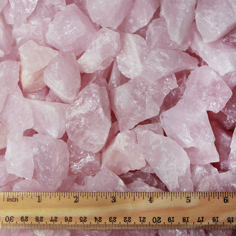 Raw rose quartz crystals with ruler for size reference