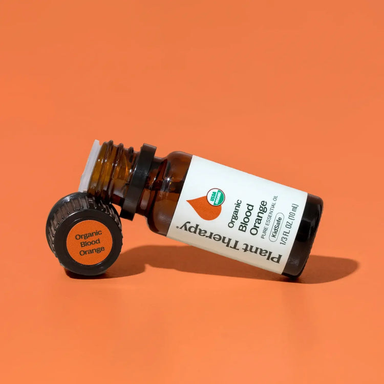 Plant Therapy organic blood orange essential oil bottle on orange background