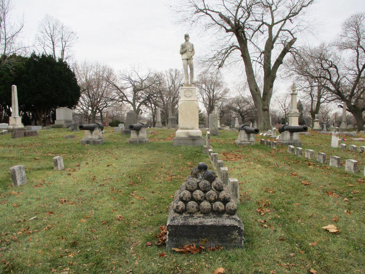 Civil War memorial statue in historic cemetery with cannons and cannonballs