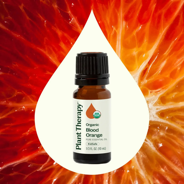 Plant Therapy organic blood orange essential oil bottle with vibrant orange fruit background
