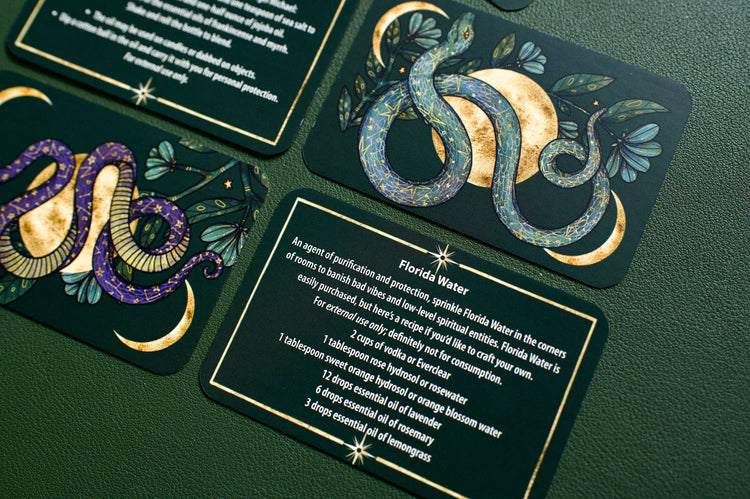 Tarot cards with illustrated snakes, moon, and text on a green background, spiritual decor.