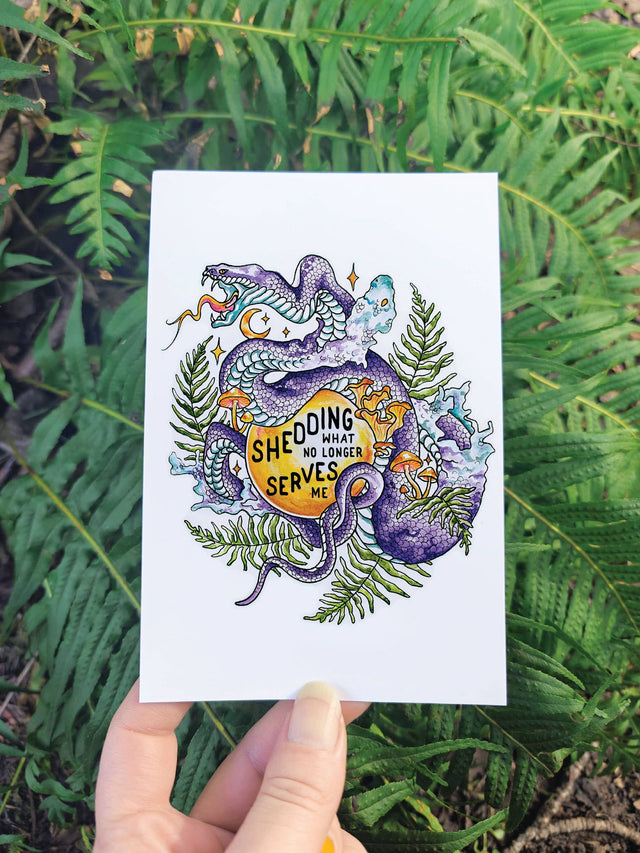 Shedding Snake sticker held up against fern leaves