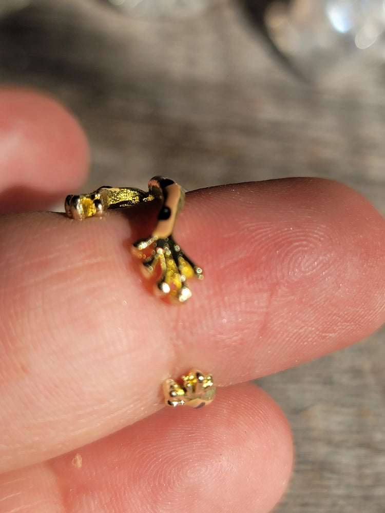 Close-up of a small gold claw-shaped ring on a finger, metaphysical jewelry