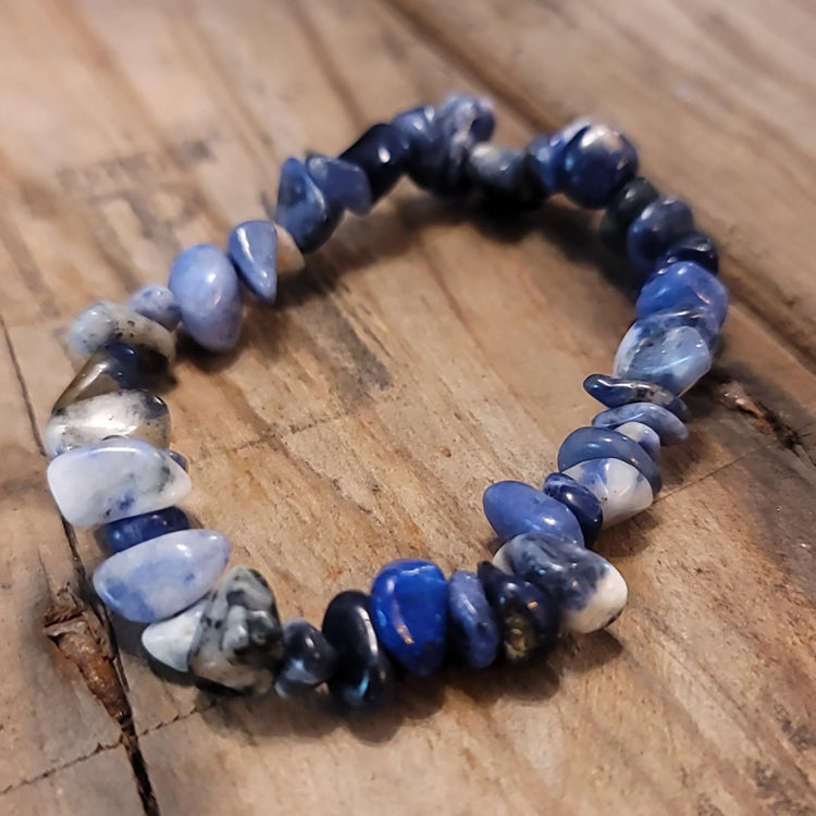 Blue sodalite chip stone bracelet on rustic wooden surface
