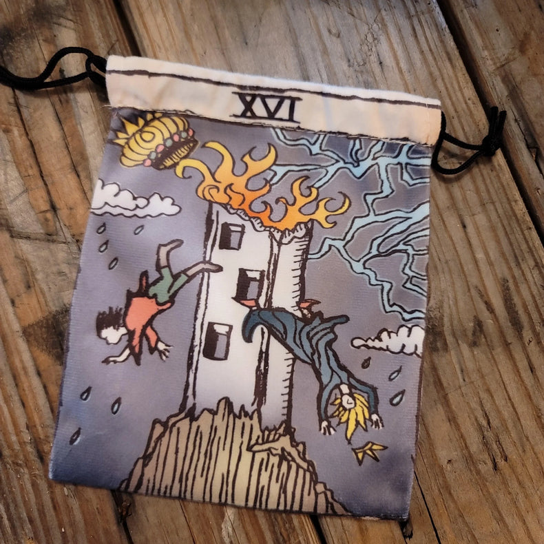 Tarot deck pouch with Tower card illustration, lightning, and flames on rustic wood table