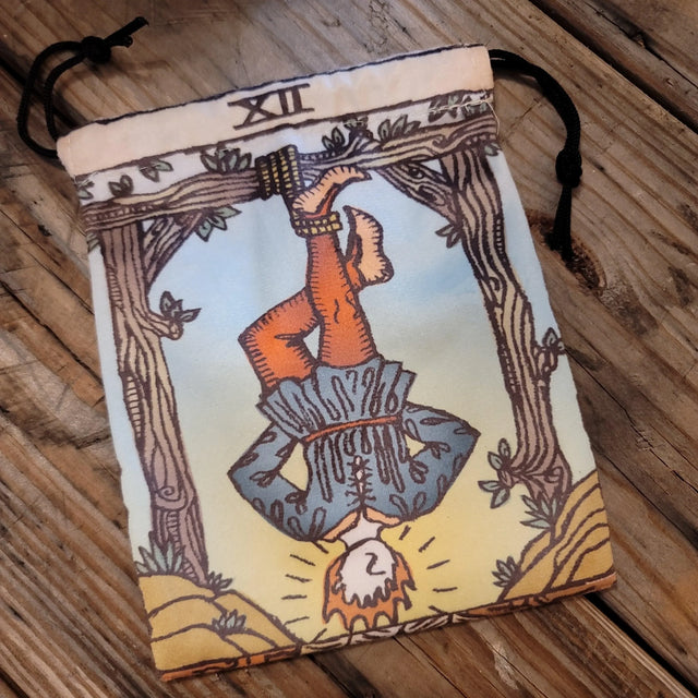 Tarot card pouch with Hanged Man design on rustic wooden surface