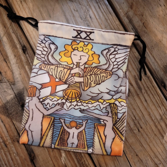 Tarot pouch with Judgment card illustration, angel, trumpet, and figures on wood surface