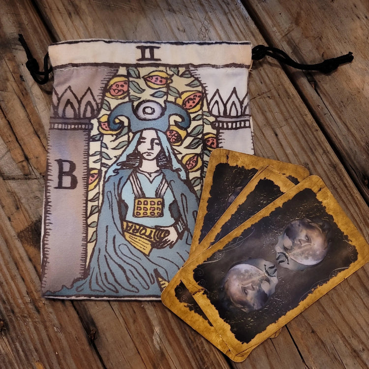 Tarot deck pouch with High Priestess illustration and three tarot cards on rustic wood