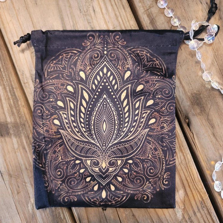 Tarot deck pouch with intricate mandala lotus design on wood background