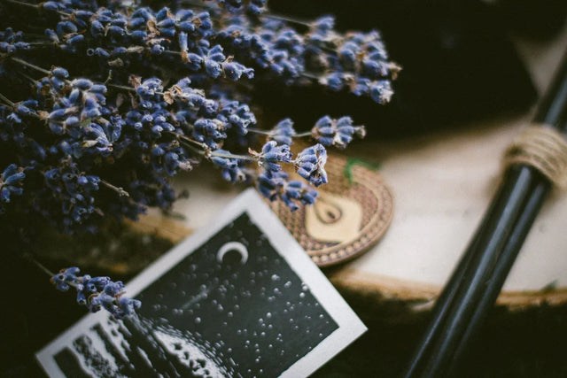 Bundle of dried lavender, tarot card, and incense sticks for spiritual rituals and healing