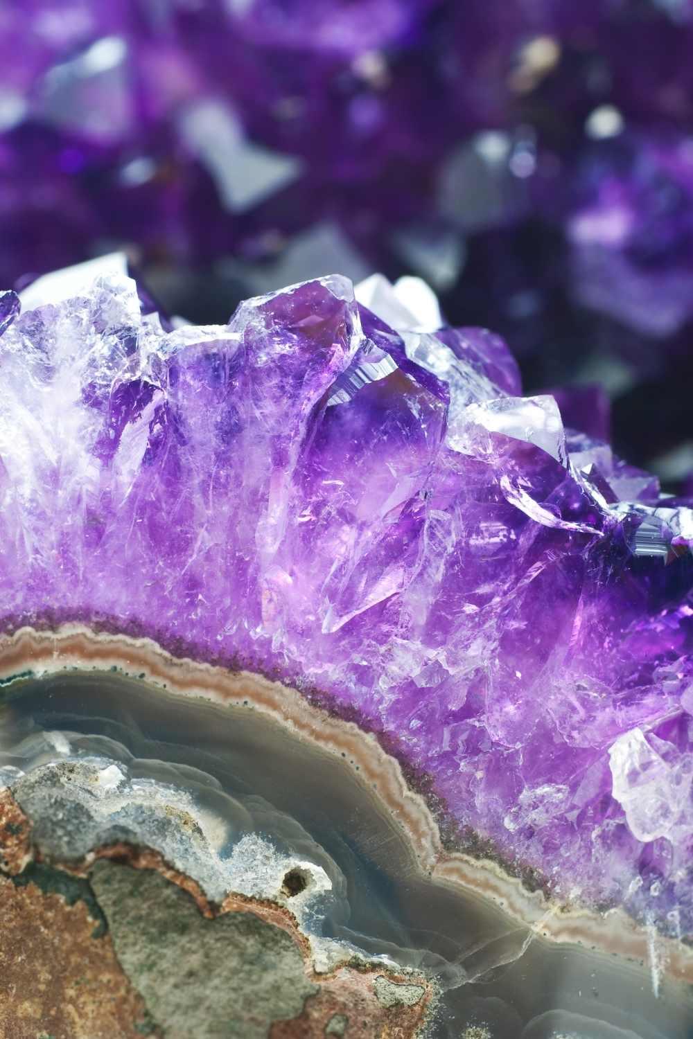 Close-up of natural amethyst crystal cluster with vibrant purple points and geode details