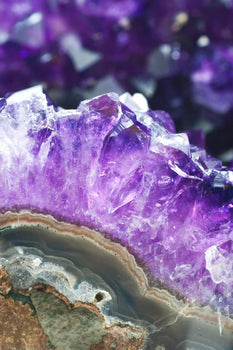 Close-up of natural amethyst crystal cluster with vibrant purple points and geode details