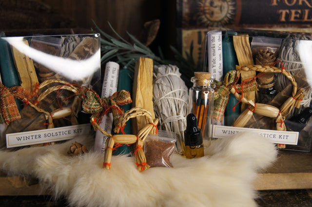 Winter Solstice ritual kits with candles, sage, essential oil, matches, and festive straw ornaments