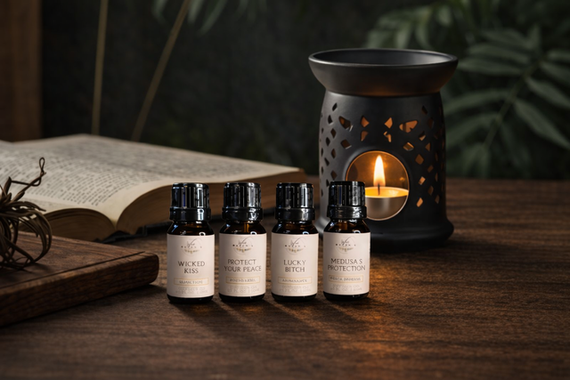 Aromatherapy oils labeled Wicked Kiss, Protect Your Peace, Lucky, Medusa's Protection with candle burner