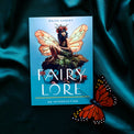 Fairy Lore book with illustrated fairy on cover and butterfly prop on teal fabric background