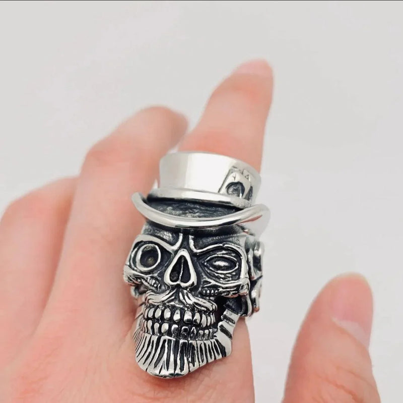 Stainless steel skull ring with top hat on finger, gothic jewelry close-up