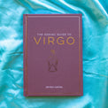 Purple Zodiac Guide to Virgo astrology book by Astrid Carvel on blue silk fabric