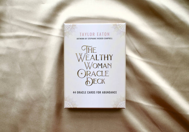 The Wealthy Woman Oracle Deck box with gold lettering on satin background, 44 oracle cards for abundance