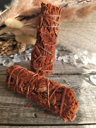 Cedar smudge sticks on rustic wood with pampas grass and clear crystals
