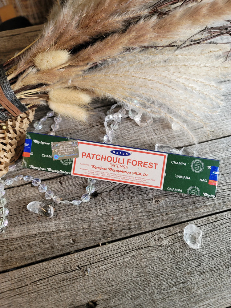 Patchouli Forest incense box on rustic wood with crystals and dried pampas grass.