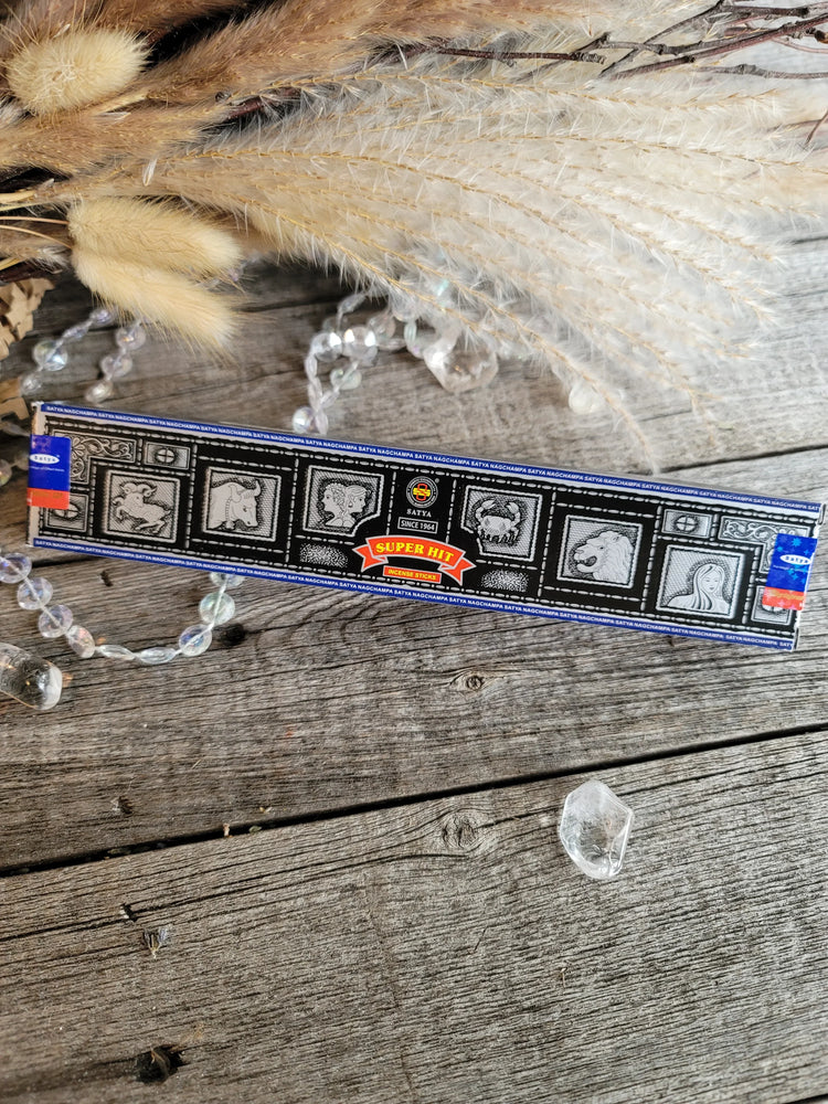 Satya Super Hit incense box with crystals and dried grass on rustic wood background