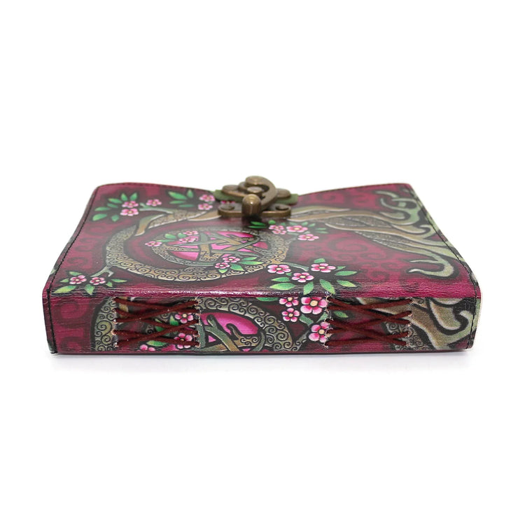 Decorative pink journal with tree of life, pentacle, floral detailing, and bronze clasp