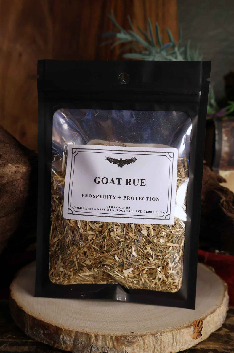 Goat rue herb in clear resealable bag labeled for prosperity and protection, on wood slice
