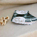 Moon phase tarot cards with celestial design, beside dried flowers on linen