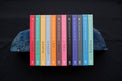 Colorful set of zodiac guide books for each astrological sign on a dark background