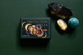 Protection Spells deck with snake design, crystals, and gemstones on green background