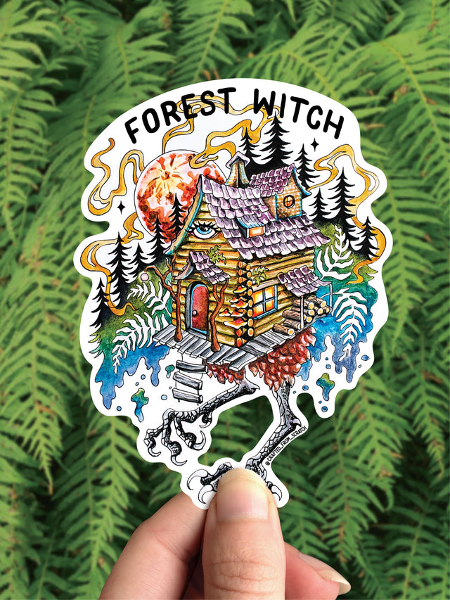 Baba Yaga Forest Witch vinyl sticker, the hut on chicken legs in a pine forest, held against ferns