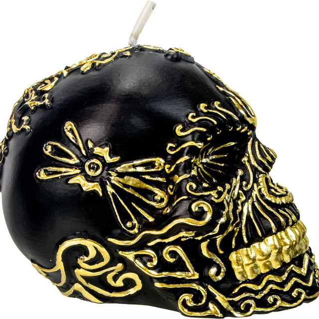 Black skull candle with intricate gold decorative patterns, metaphysical decor