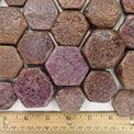 Hexagonal raw ruby crystals arranged with a wooden ruler for scale