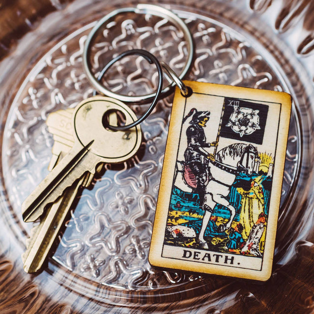 Wooden Death tarot card keychain with vintage keys on ornate glass dish