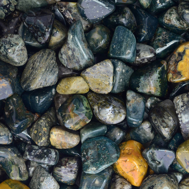 Polished moss agate tumbled stones in green, yellow, and gray tones for crystal healing