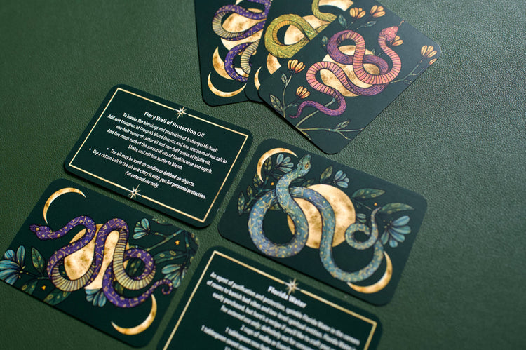 Tarot cards with colorful snake and moon designs on a green table, metaphysical decor