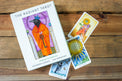 Radiant Tarot deck box and cards with vibrant illustrations on wood background