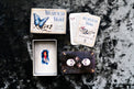 Memento Mori oracle card deck with skull, butterfly, and candle artwork on textured surface
