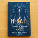 Hekate Goddess of Witches book by Courtney Weber on yellow background, mystical dark cover