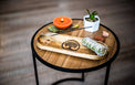 Sage bundle, incense stick, candle, plant, and crystals on a round wooden table